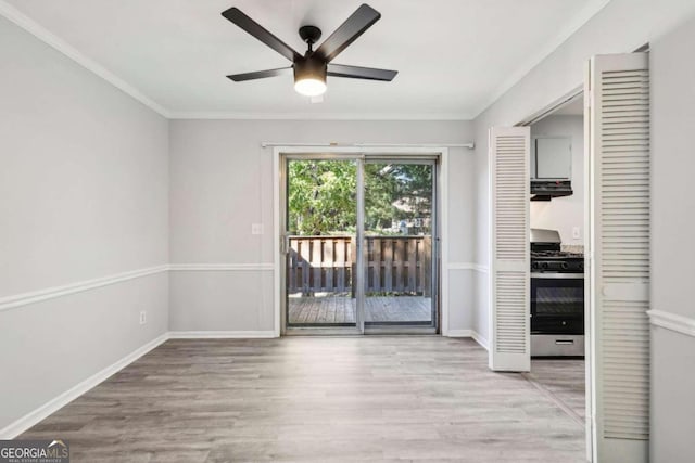 spare room with ornamental molding, light wood-type flooring, and ceiling fan