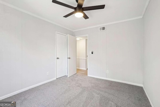 carpeted spare room with ornamental molding and ceiling fan