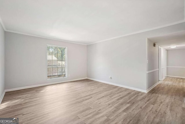 unfurnished room featuring ornamental molding and light wood-type flooring