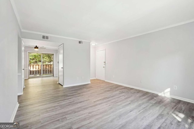 empty room with ornamental molding, light wood-type flooring, and ceiling fan