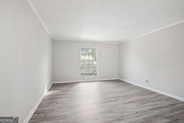 unfurnished room featuring wood-type flooring and ornamental molding