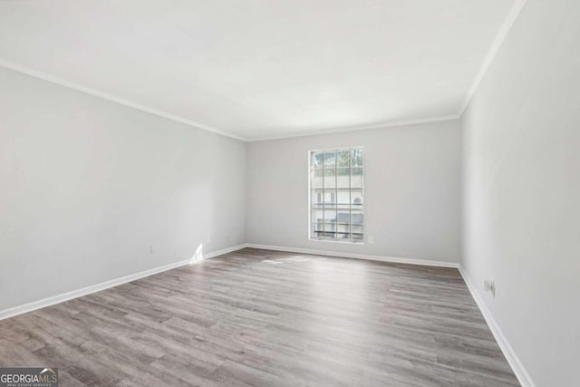 empty room featuring ornamental molding and wood-type flooring