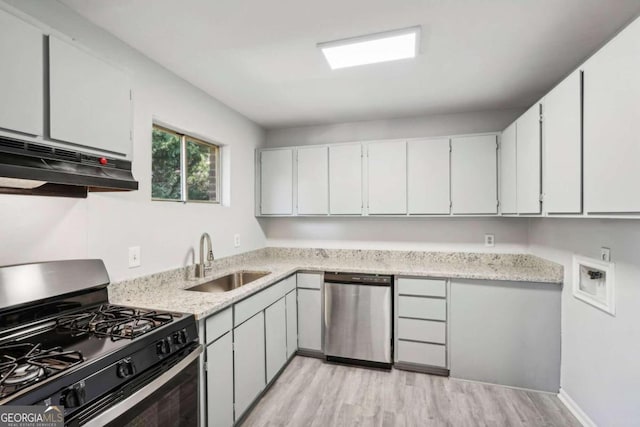 kitchen with sink, white cabinets, stainless steel appliances, and light hardwood / wood-style floors