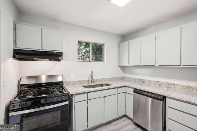 kitchen with sink, appliances with stainless steel finishes, light hardwood / wood-style flooring, and white cabinetry