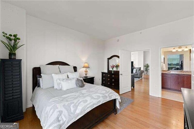 bedroom with hardwood / wood-style flooring and ensuite bath