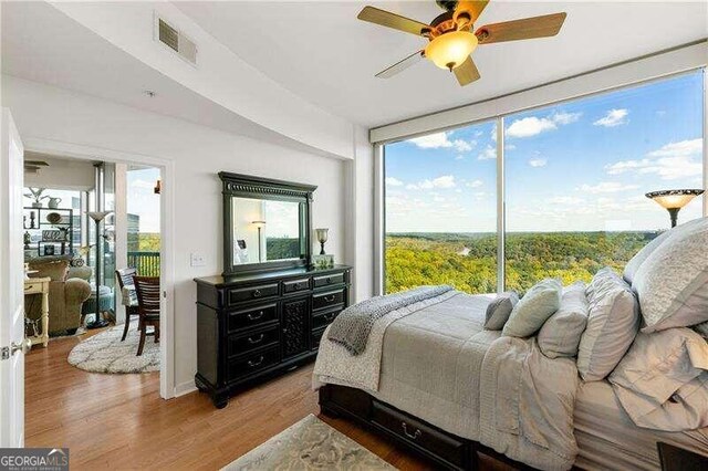 bedroom featuring hardwood / wood-style floors, access to exterior, and ceiling fan