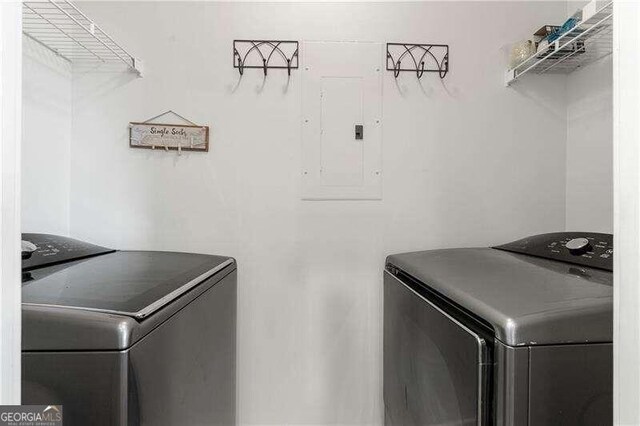 laundry room with electric panel and washing machine and dryer