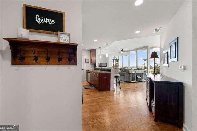 corridor featuring light hardwood / wood-style floors, sink, and floor to ceiling windows