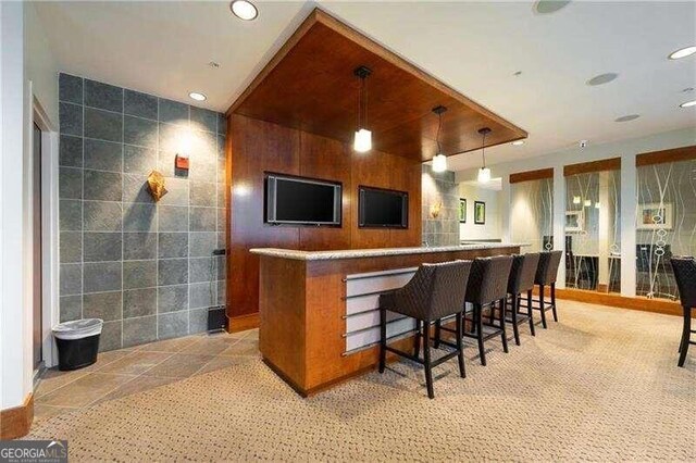 bar with tile walls and hanging light fixtures