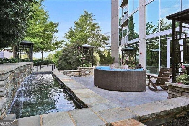 view of patio / terrace featuring a gazebo and pool water feature