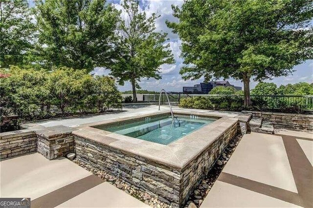 view of swimming pool featuring an in ground hot tub and a patio area