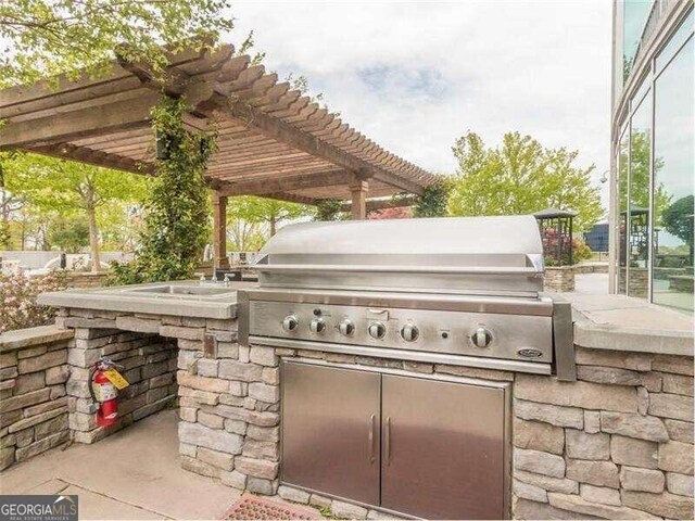 view of patio with area for grilling, a pergola, and grilling area