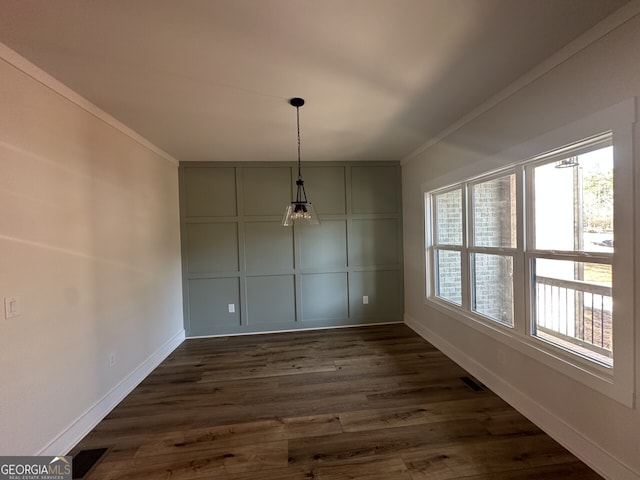 unfurnished dining area featuring ornamental molding, dark wood-type flooring, and a wealth of natural light