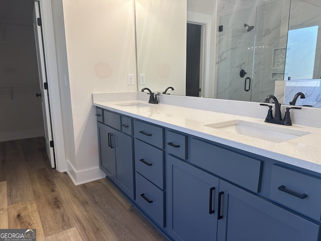 bathroom featuring vanity, wood-type flooring, and walk in shower