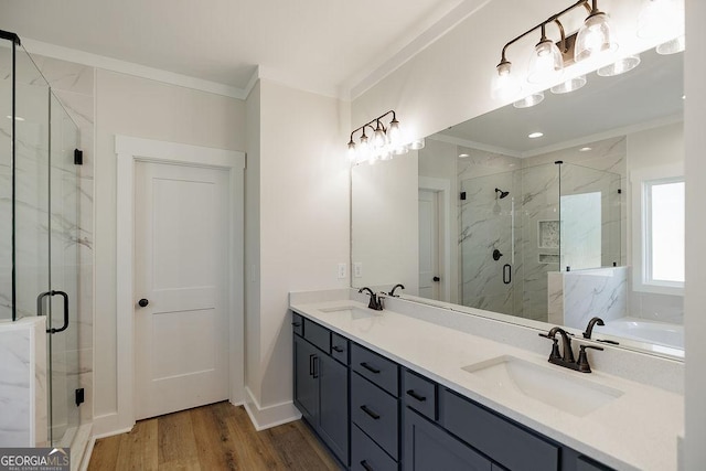 bathroom with crown molding, vanity, a shower with shower door, and wood-type flooring