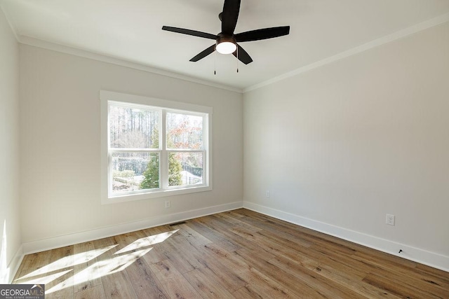 empty room featuring ceiling fan, ornamental molding, and light wood-type flooring