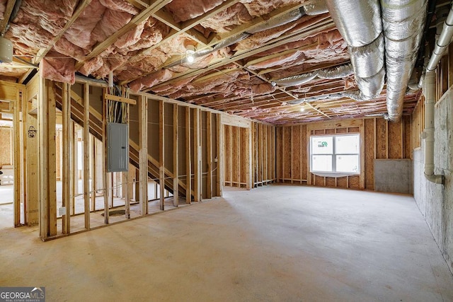 miscellaneous room with electric panel and concrete flooring