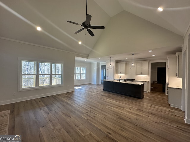 unfurnished living room with dark hardwood / wood-style flooring, sink, high vaulted ceiling, and ceiling fan