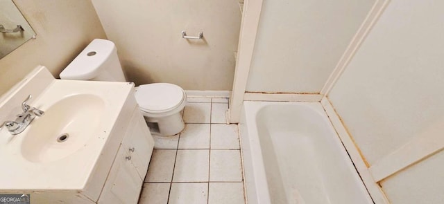 bathroom featuring vanity, toilet, tile patterned flooring, and a bathing tub