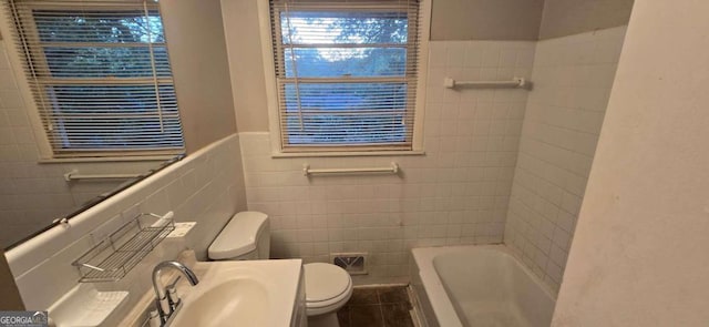 full bathroom featuring toilet, plus walk in shower, vanity, and tile walls