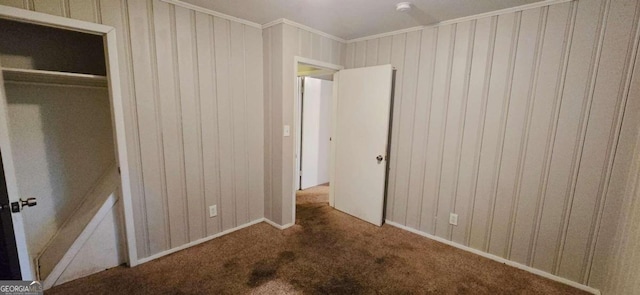 unfurnished bedroom with a closet, carpet, and ornamental molding