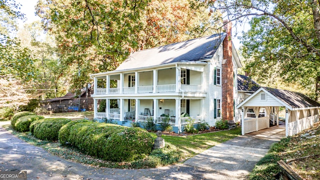 view of front of home with a balcony, covered porch, and a carport