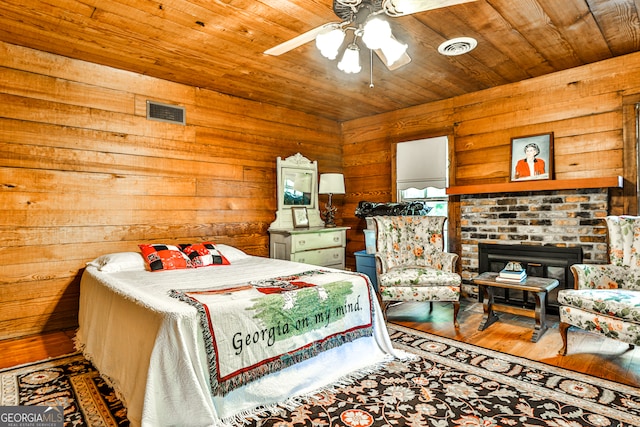 bedroom featuring wooden walls, hardwood / wood-style floors, wooden ceiling, and ceiling fan