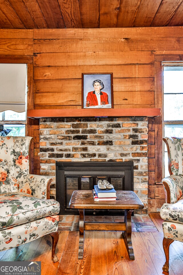 room details with wooden ceiling, wood-type flooring, and a brick fireplace