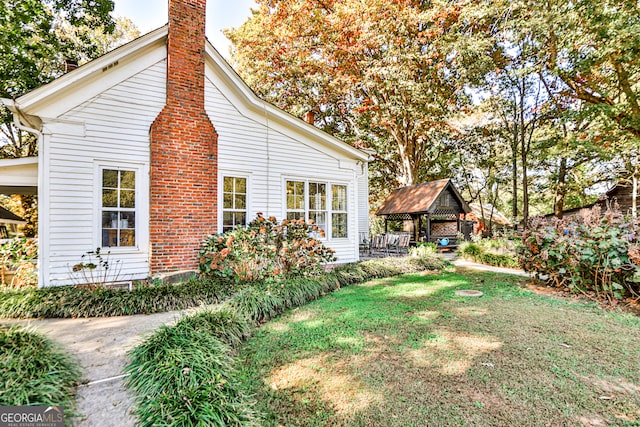 view of property exterior featuring a gazebo and a lawn