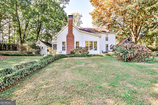 back of house with a lawn