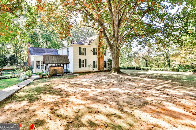 164 Manning Gin Rd, Bethlehem, GA 30620 - rear view of house featuring a chimney and view of scattered trees