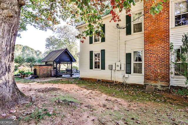 rear view of house with a gazebo, a mountain view, and a patio area