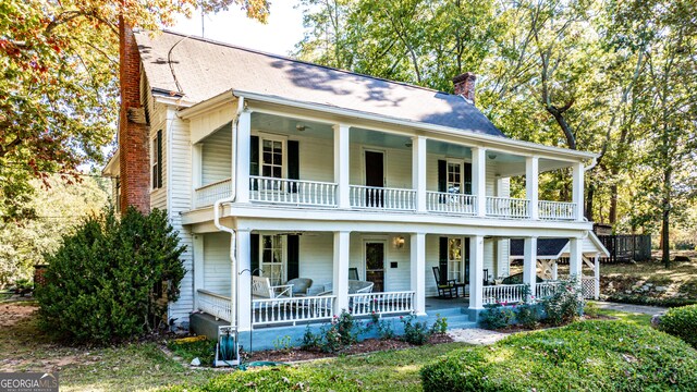 164 Manning Gin Rd, Bethlehem, GA 30620 - neoclassical home featuring a balcony, covered porch, a chimney, and roof with shingles