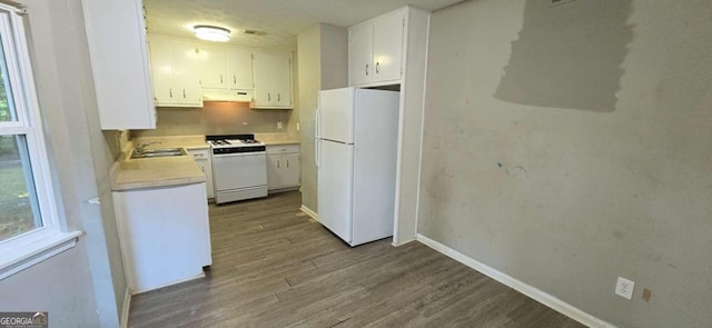 kitchen with white appliances, dark wood-type flooring, white cabinetry, and sink