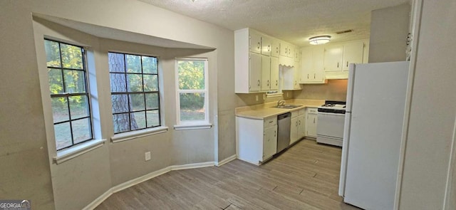 kitchen with white appliances, sink, a textured ceiling, light hardwood / wood-style floors, and white cabinets