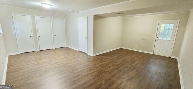 foyer entrance featuring ornamental molding, wood finished floors, and baseboards