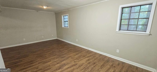 unfurnished room with ornamental molding, baseboards, and dark wood finished floors