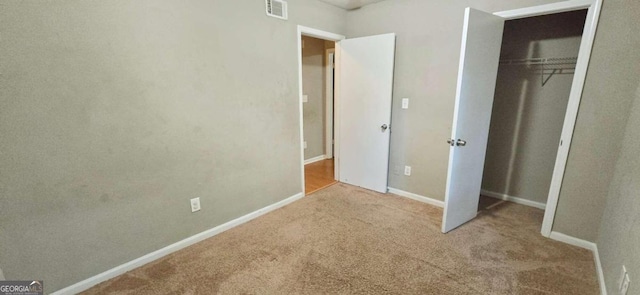 unfurnished bedroom with a closet and light carpet