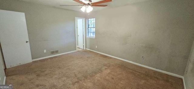 carpeted spare room featuring visible vents, ceiling fan, and baseboards