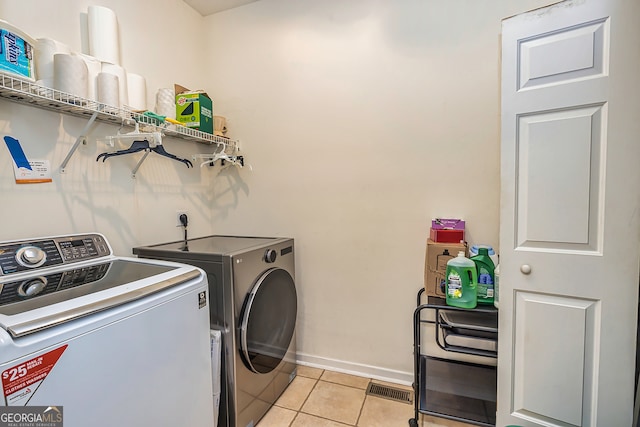 laundry room with washing machine and dryer and light tile patterned floors