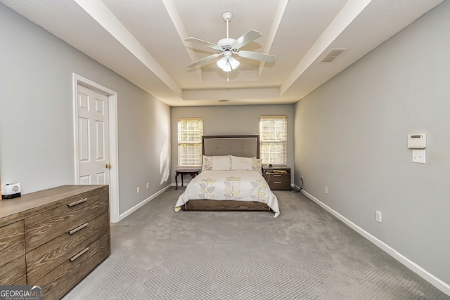 unfurnished bedroom featuring carpet, a raised ceiling, and ceiling fan