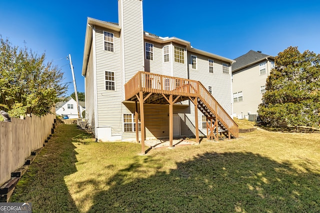 rear view of property with a wooden deck and a yard