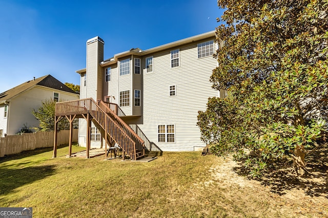 back of property with a yard and a wooden deck