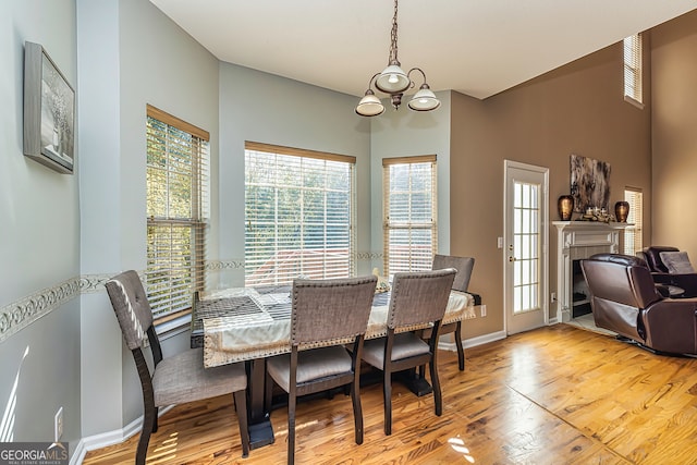 dining area featuring an inviting chandelier, a fireplace, and light wood-type flooring