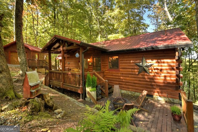 exterior space with a fire pit and a wooden deck