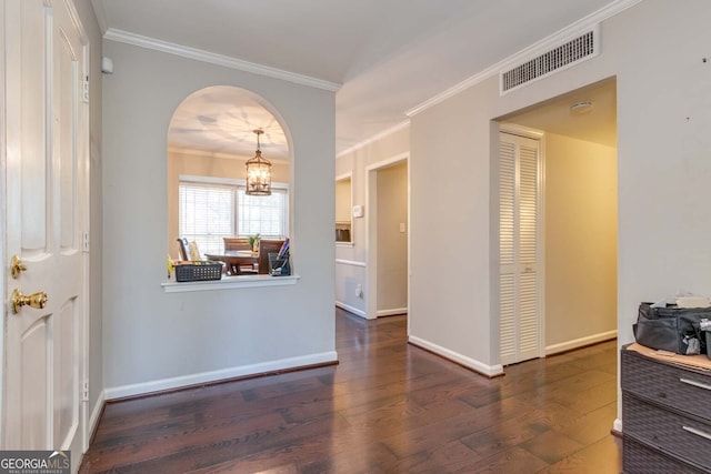 interior space featuring crown molding, dark hardwood / wood-style floors, and a notable chandelier