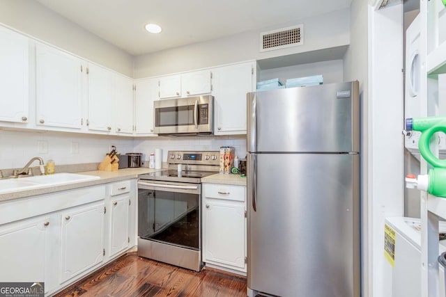 kitchen featuring sink, backsplash, dark hardwood / wood-style flooring, stainless steel appliances, and white cabinets