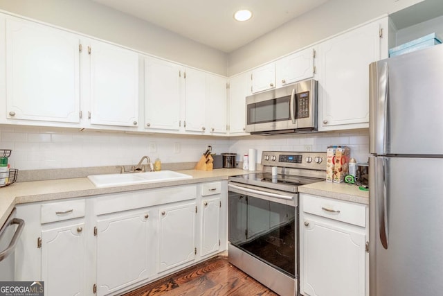 kitchen featuring backsplash, sink, white cabinetry, appliances with stainless steel finishes, and dark hardwood / wood-style flooring