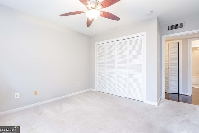 unfurnished bedroom with a closet, ceiling fan, and light colored carpet