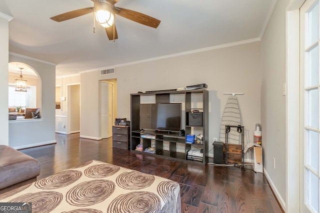 living room featuring ceiling fan with notable chandelier, ornamental molding, and dark hardwood / wood-style floors